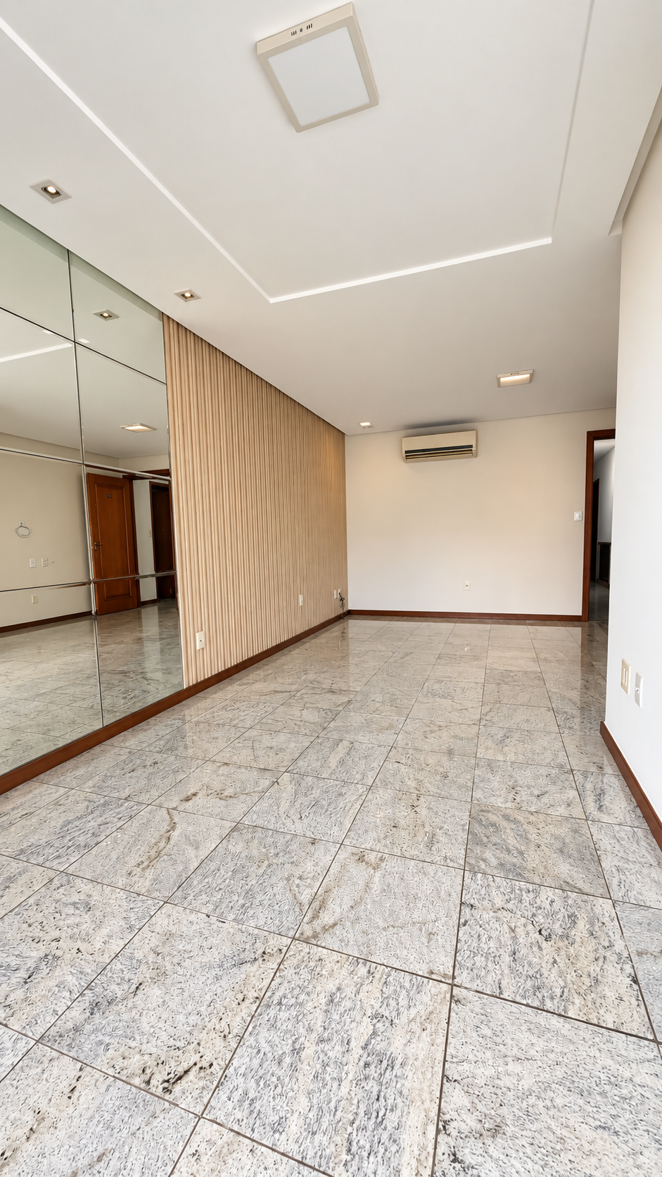 Sala ampla com painel ripado e parede espelhada