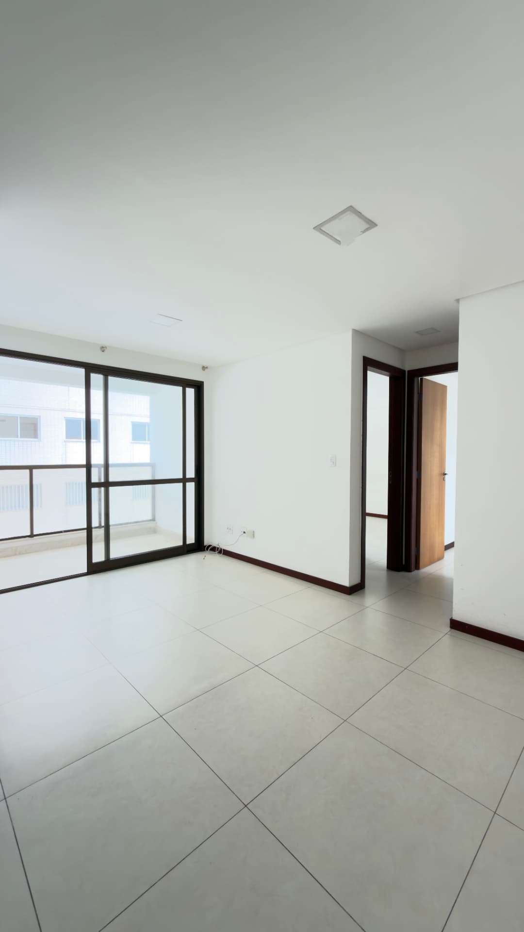 Sala ampla com porta de vidro para a varanda