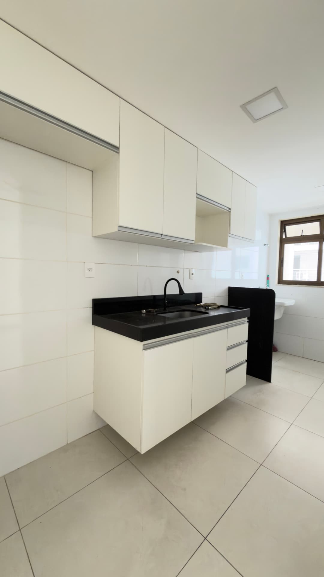 Cozinha com armários claros e bancada escura